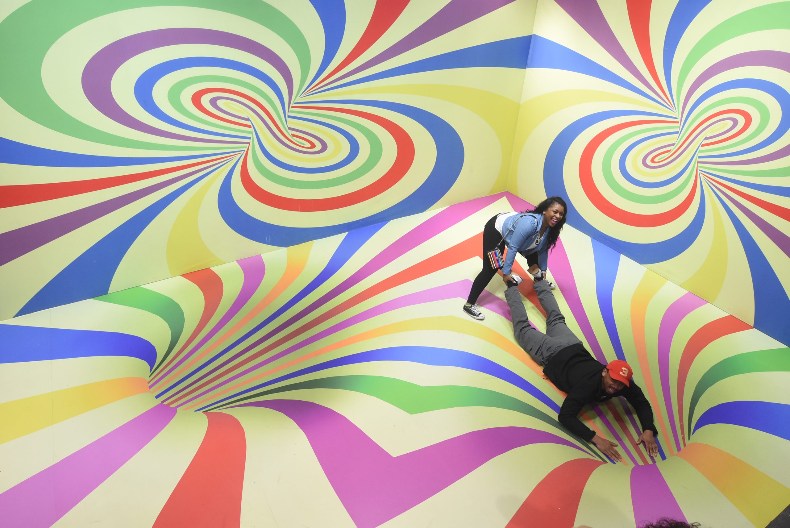 Woman plays on a 3D illusion swirling interactive art piece in an Atlanta museum.