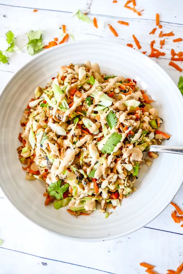 Vegan egg roll in a bowl with green garnish and dresssing.