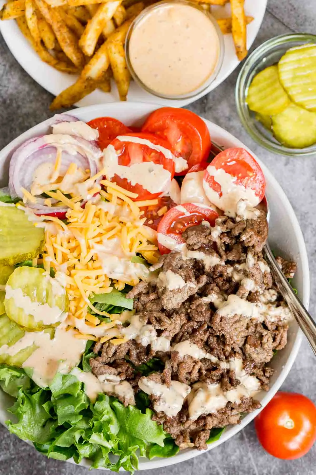 Cheeseburger bowl with pickles, onion, and tomat.