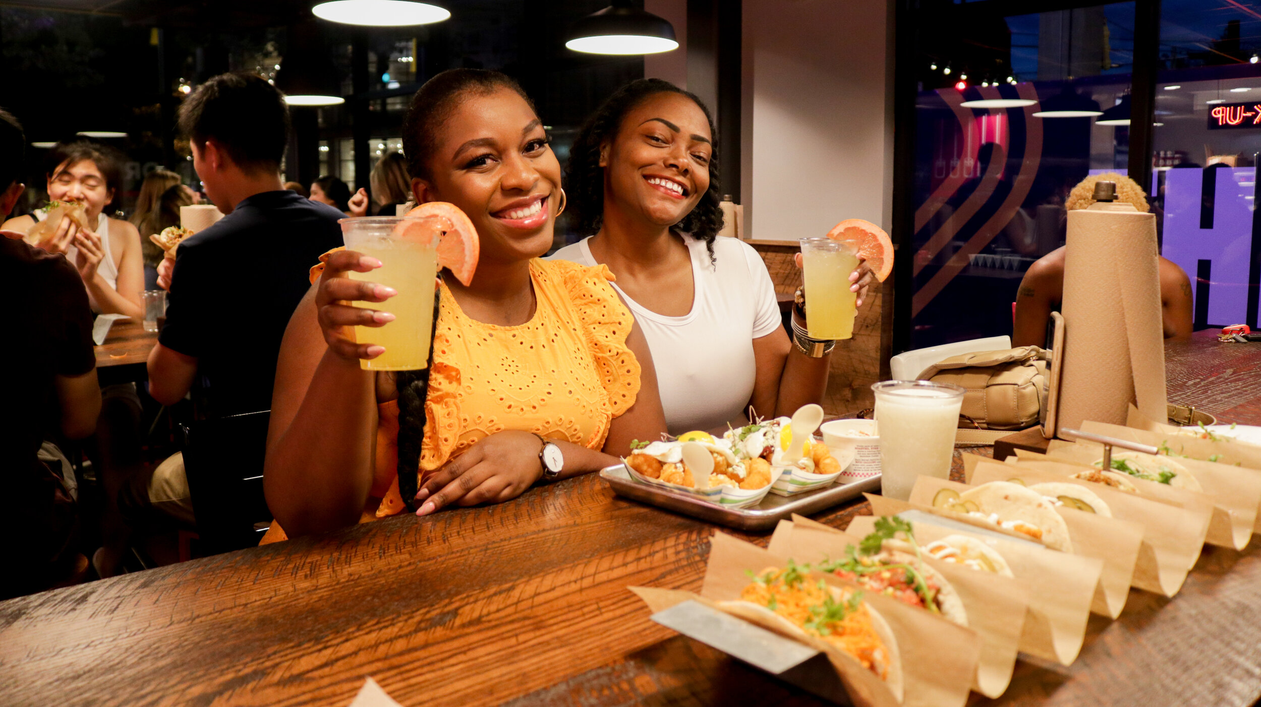 Two girl friends enjoy a taco dinner at a vibey downtown restaurant.