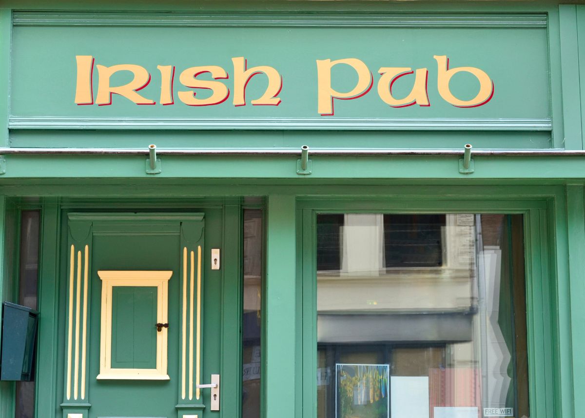 A green building with gold accents that says "Irish Pub".