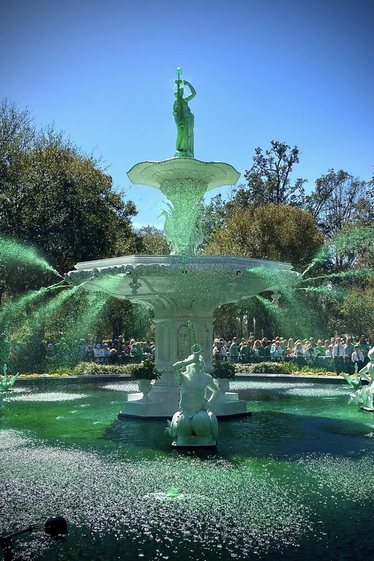 A fountain with green water in a square for St. Patrick's Day.