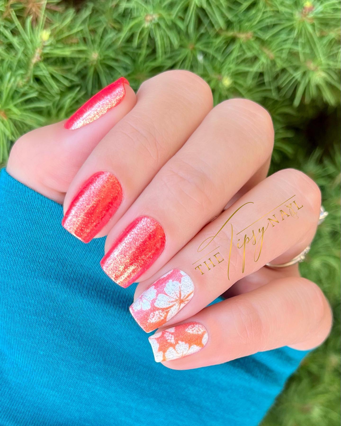 Shimmery orange nails with white Hawaiian flowers.