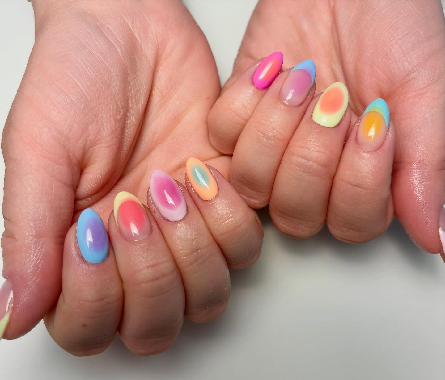 Blue, pink, yellow, and orange almond-shaped aura nails.