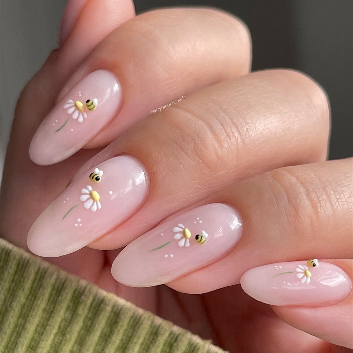 Nude nails with mini daisy and honey bee nail art.
