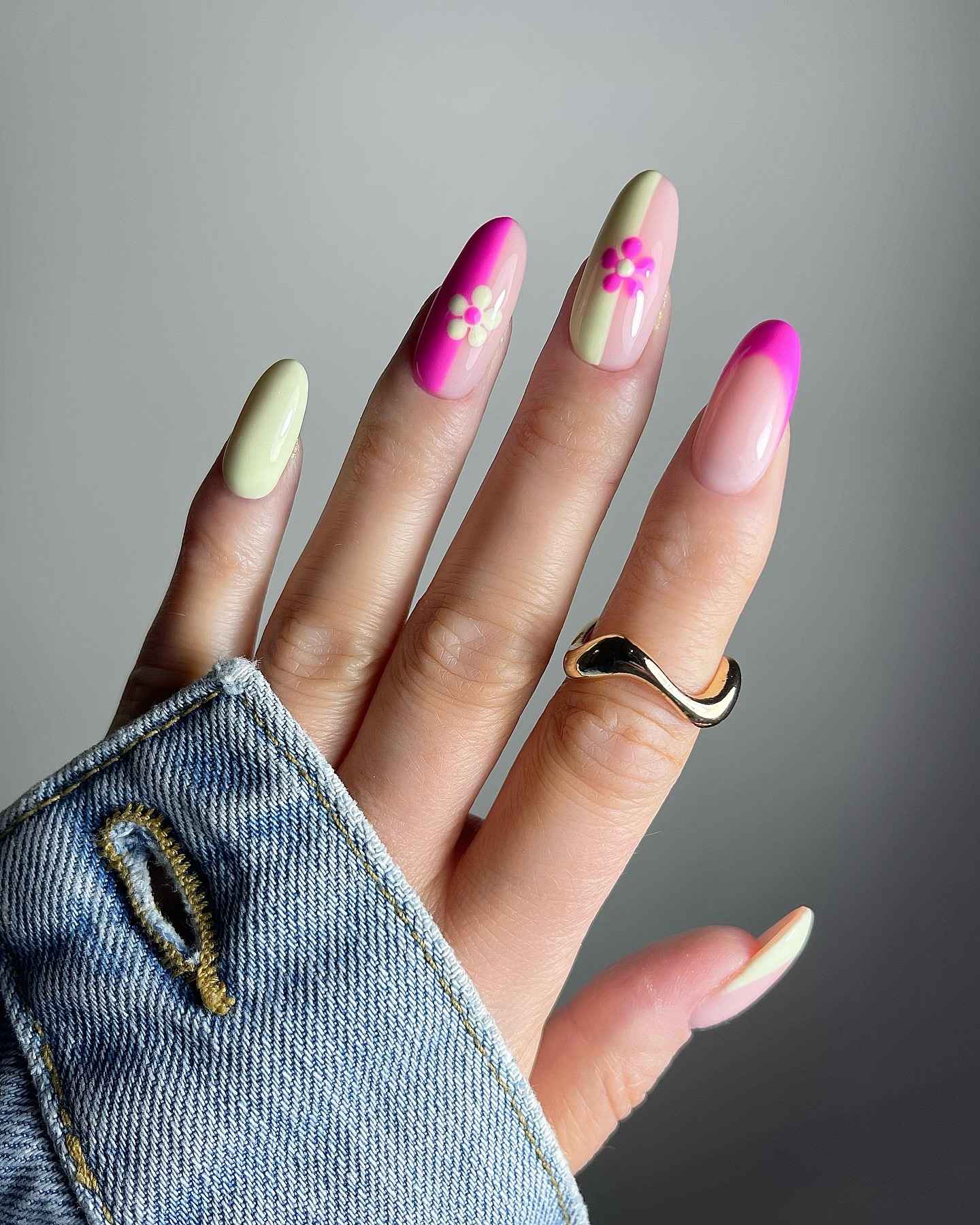 Pale green and hot pink almond nails with a floral design.