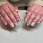 Nude nails with blue floral nail art.