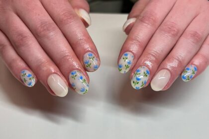Nude nails with blue floral nail art.