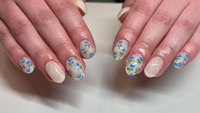 Nude nails with blue floral nail art.
