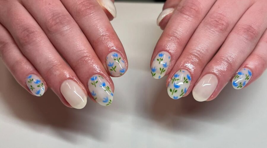 Nude nails with blue floral nail art.