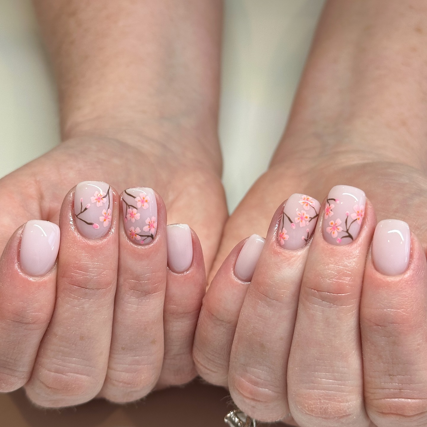 Nude French Tip nails with cherry blossom nail art.