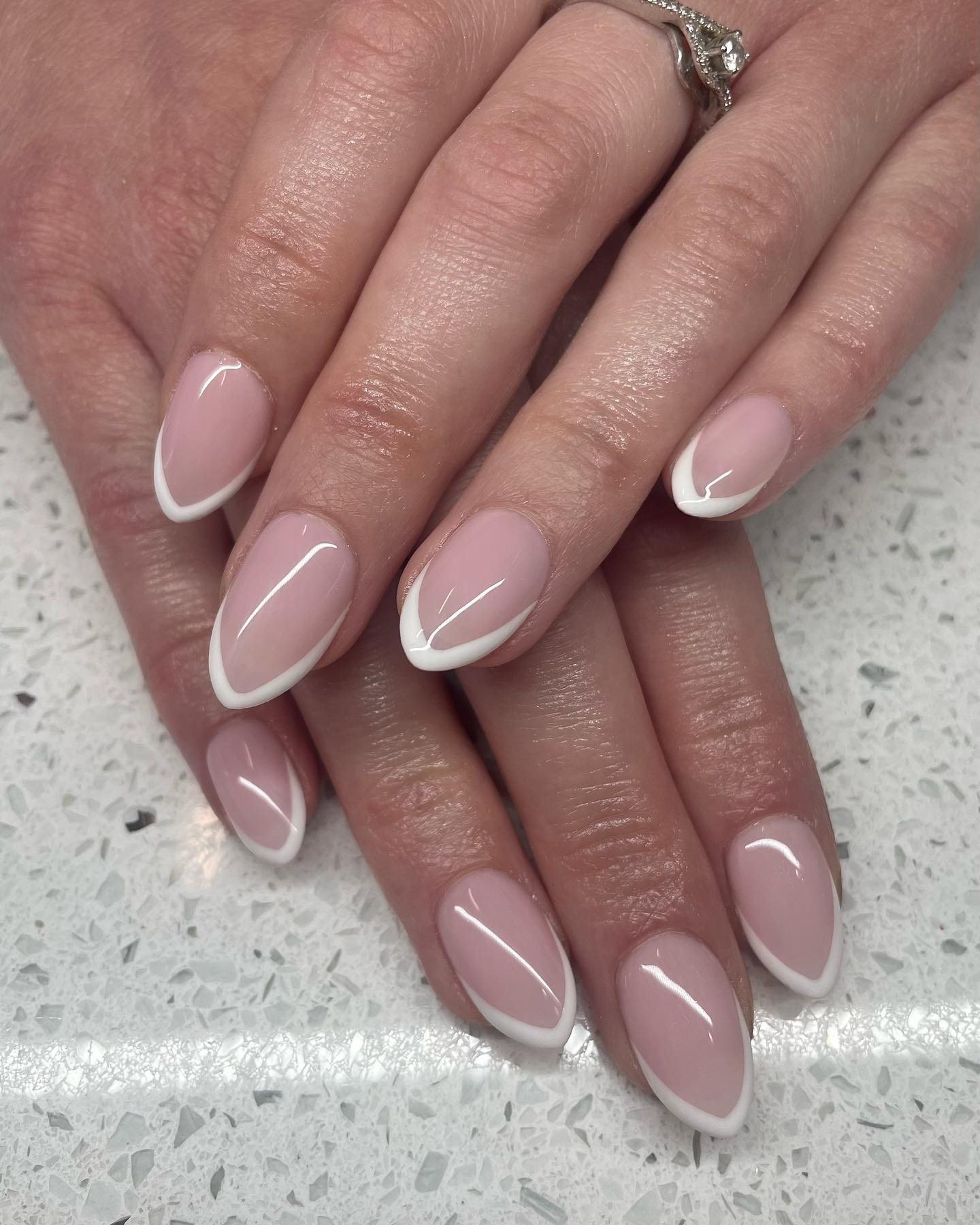 Almond French tip nails with a thin white tip.