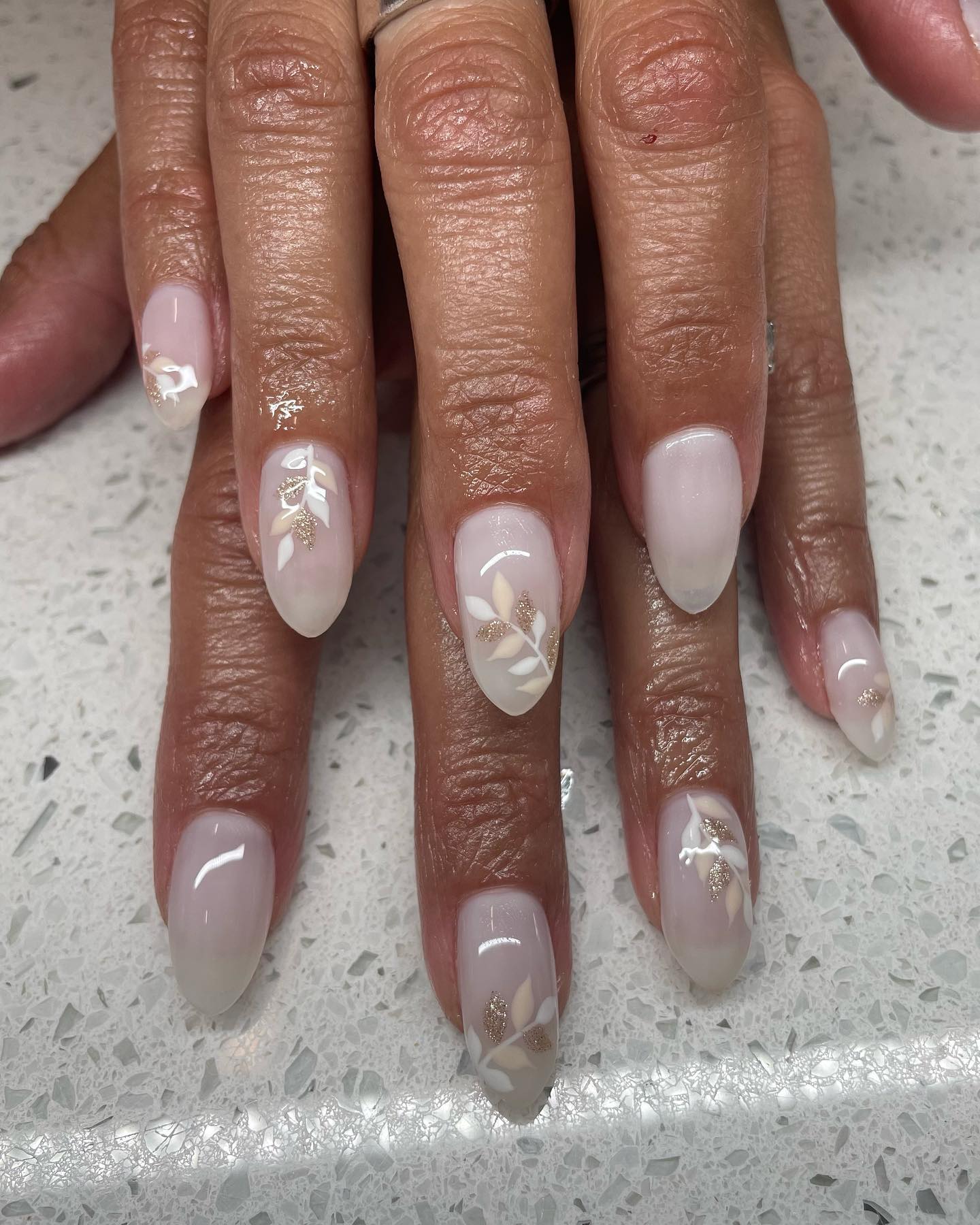 Milky white nails with palm frond designs on accent nails.