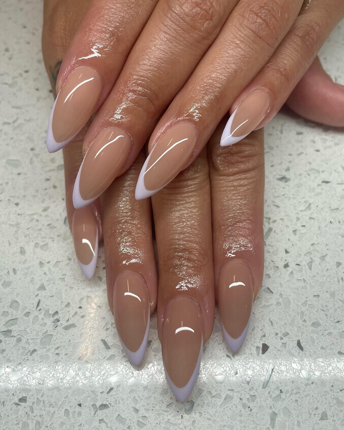 Brown stilleto nails with thin periwinkle tips.