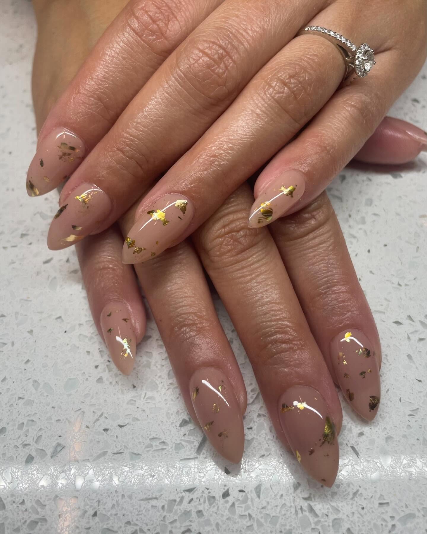 Nude nails with gold leaf accents.