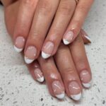 Almond French tip nails with clear rhinestones.