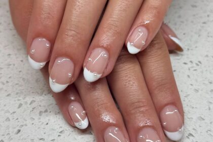 Almond French tip nails with clear rhinestones.