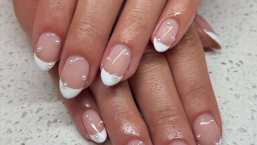 Almond French tip nails with clear rhinestones.