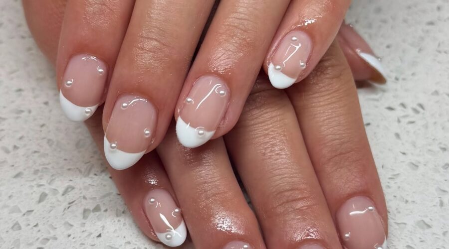 Almond French tip nails with clear rhinestones.