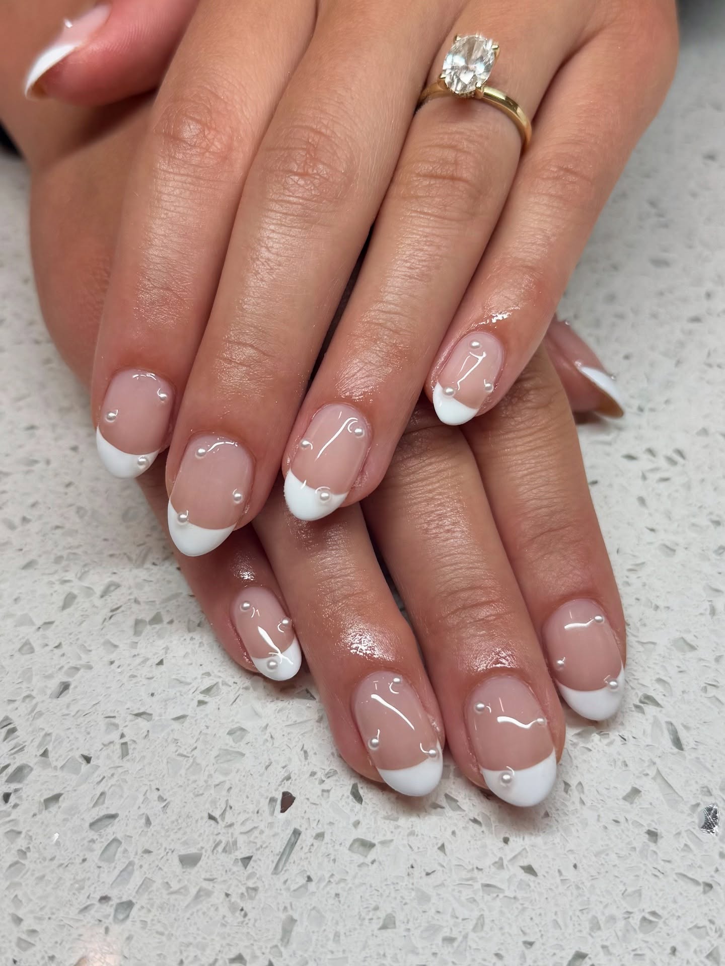 Almond French tip nails with clear rhinestones.
