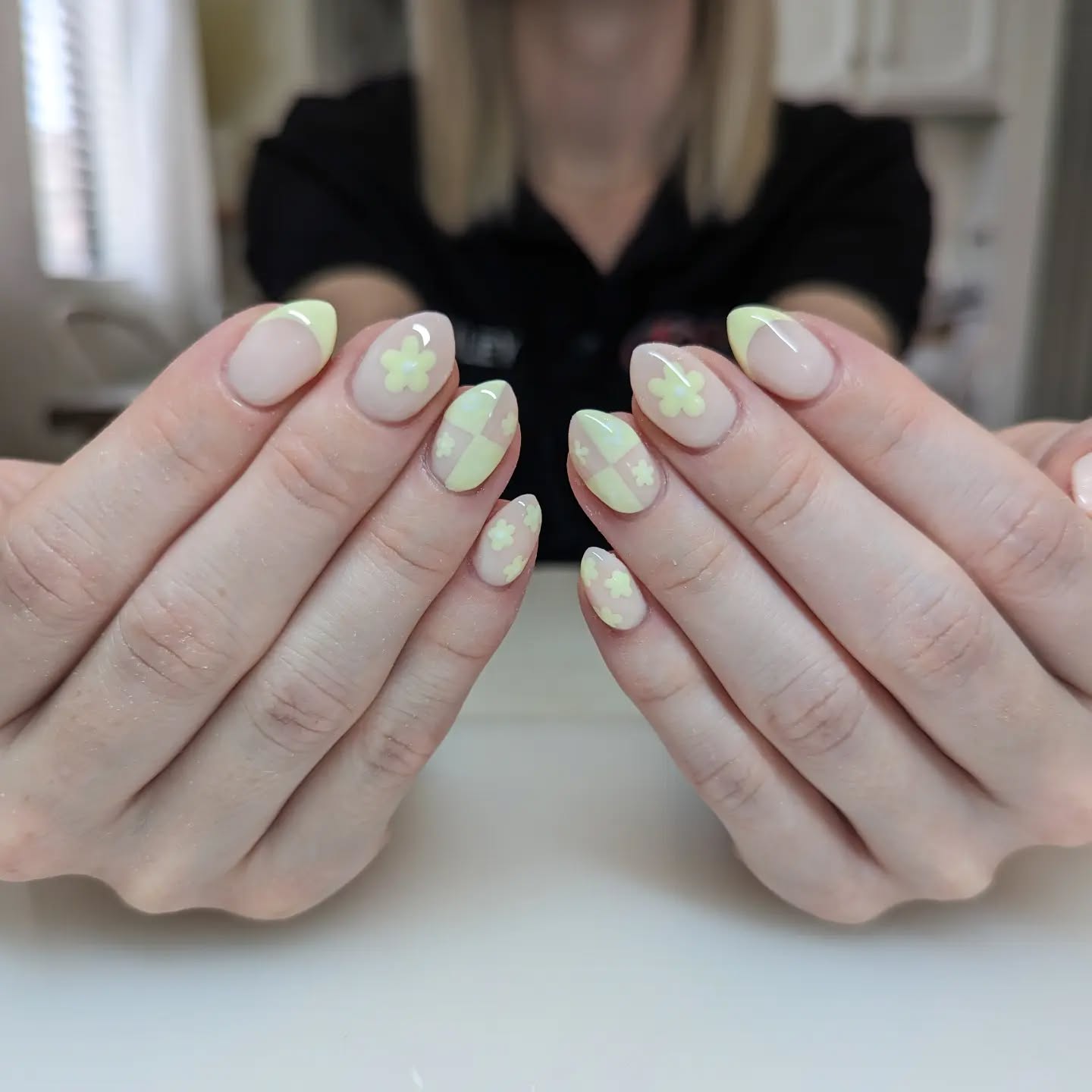 Nude nails with neon yellow designs in various shapes.