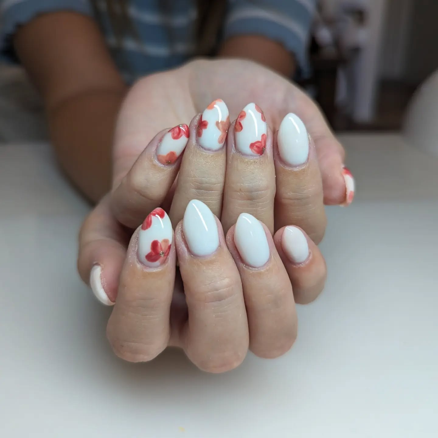 White nails with coral floral accent designs,