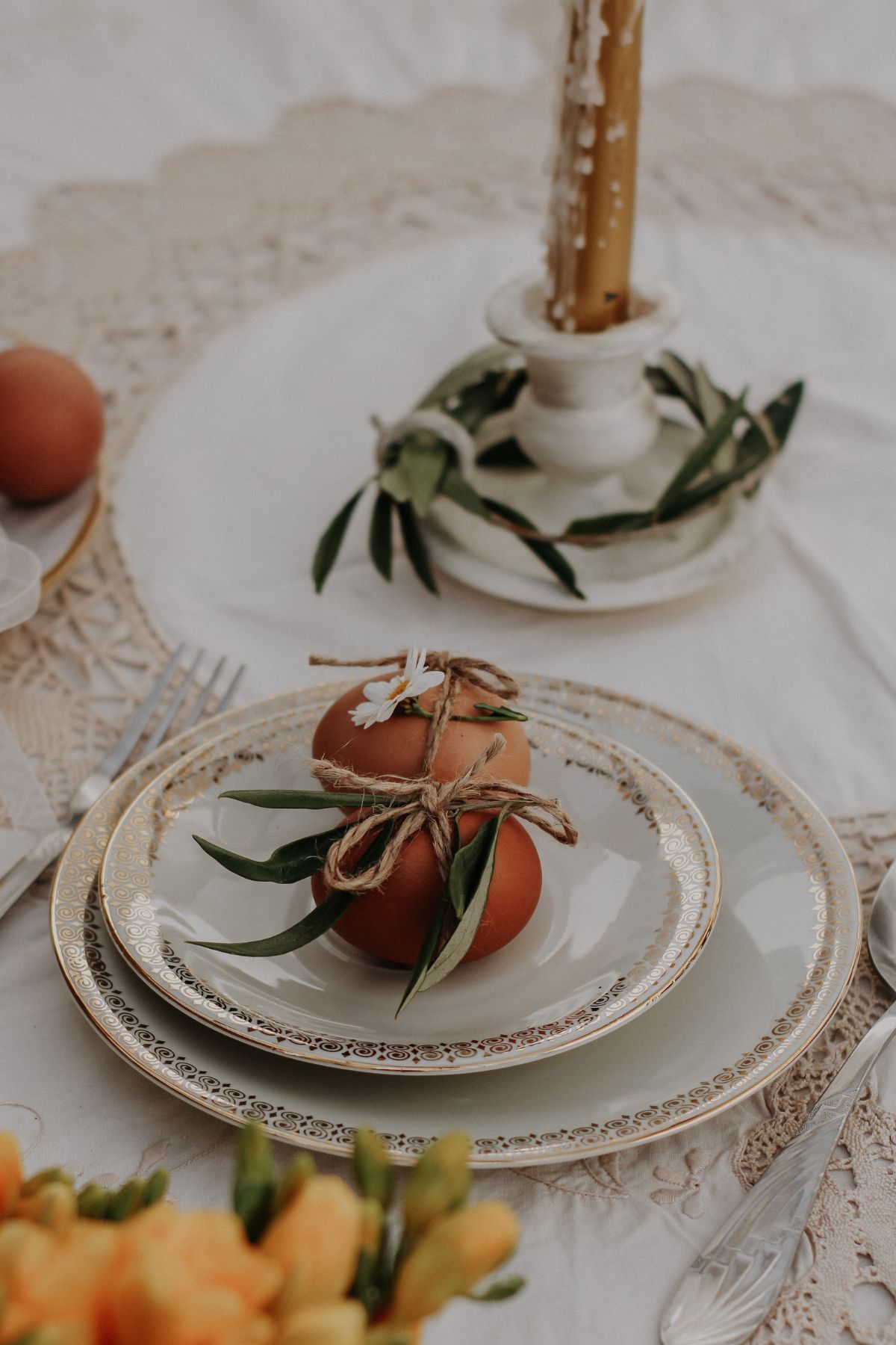 Easter place setting with brown eggs and rustic leaves tied with twine.