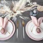 Pink and white place settings with brown eggs wrapped in pink napkins with twine.