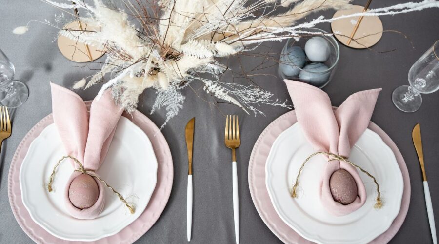 Pink and white place settings with brown eggs wrapped in pink napkins with twine.