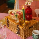 A picnic basket with candles on a table indoors.