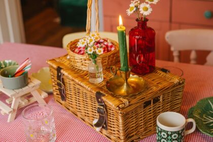 A picnic basket with candles on a table indoors.