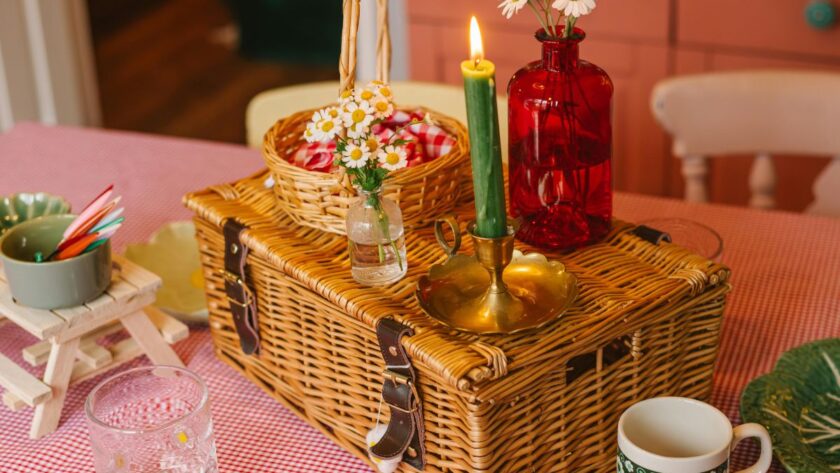 A picnic basket with candles on a table indoors.