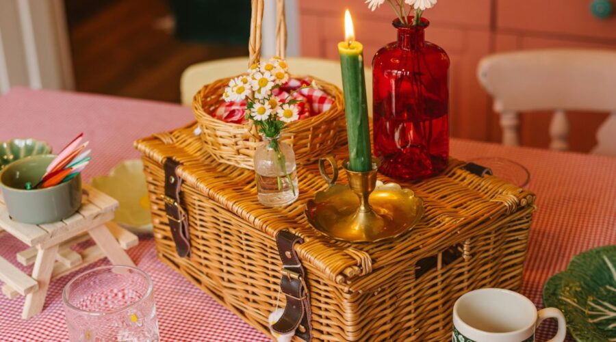 A picnic basket with candles on a table indoors.