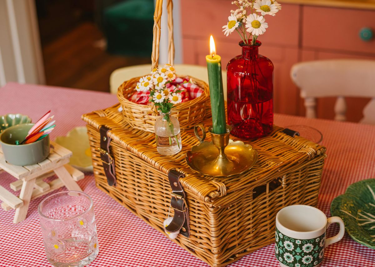 A picnic basket with candles on a table indoors.