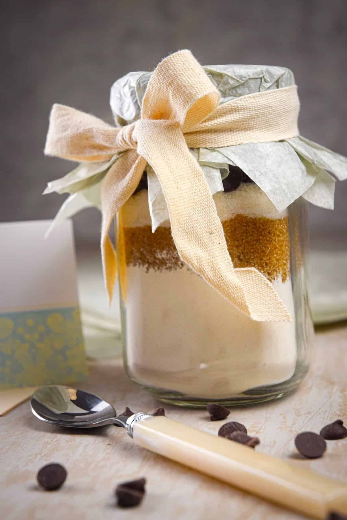 Cookies in a jar kit in a mason jar with a tan ribbon.